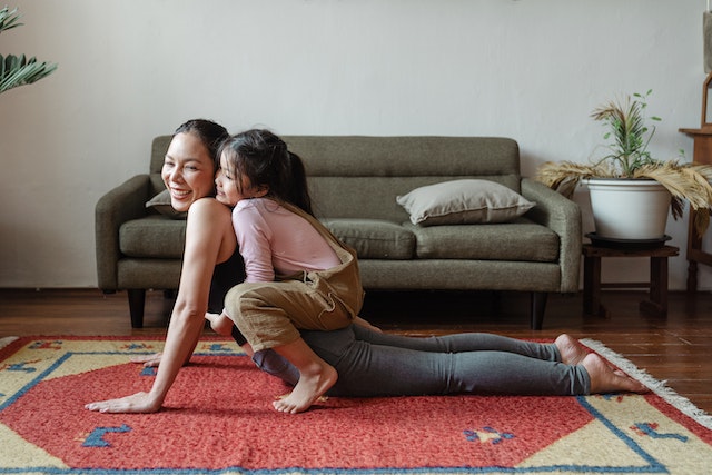 woman doing yoga with daughter