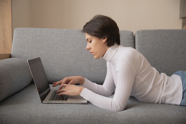 woman using laptop on couch